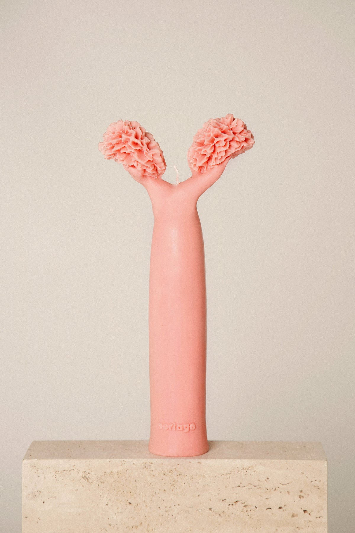 Vela Baobá artesanal na cor rosa sobre pedestal de pedra
